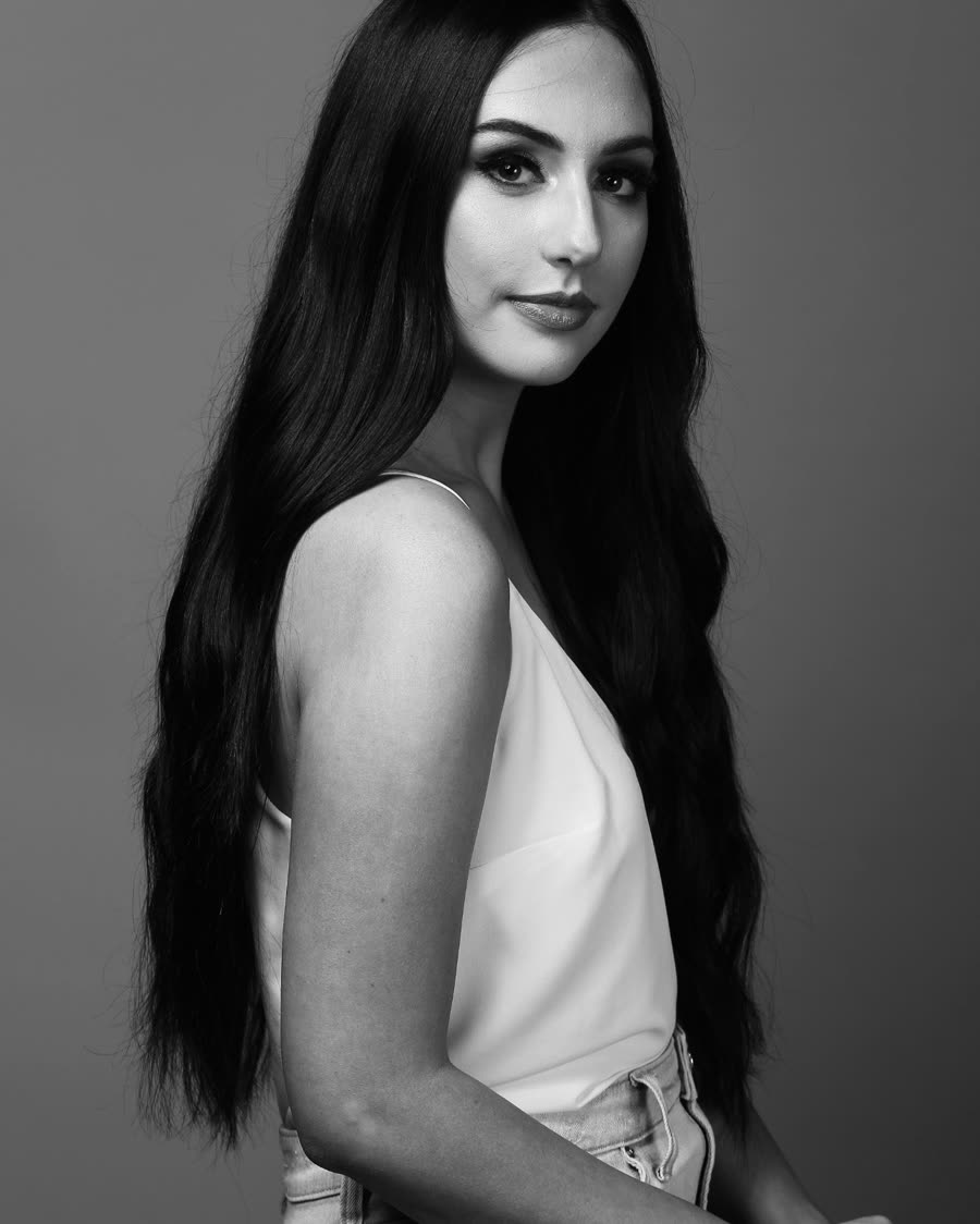 Tape-in hair extensions worn long and straight, side profile in studio
